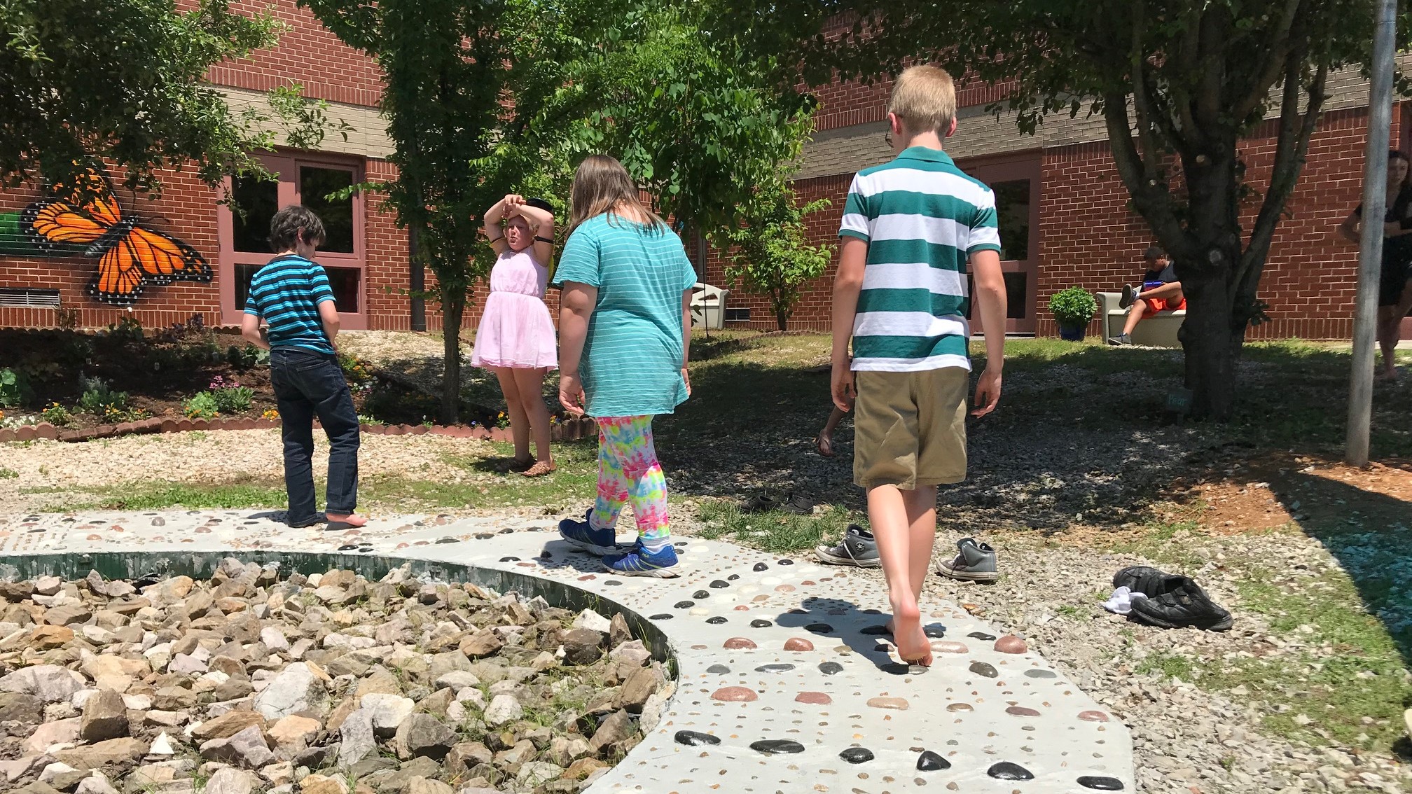 Students navigate a footpath during a ribbon-cutting for Dogwood Elementary's new Outdoor Sensory Courtyard. 